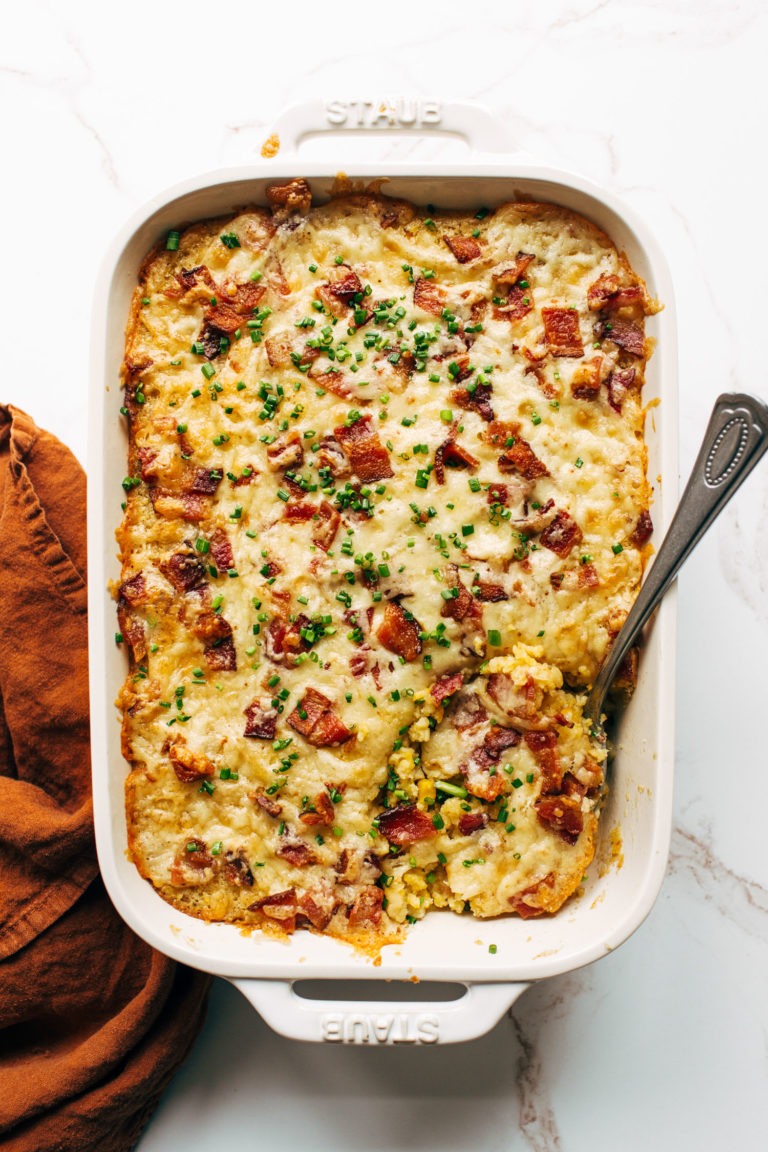 Corn casserole in a casserole dish with a serving spoon.